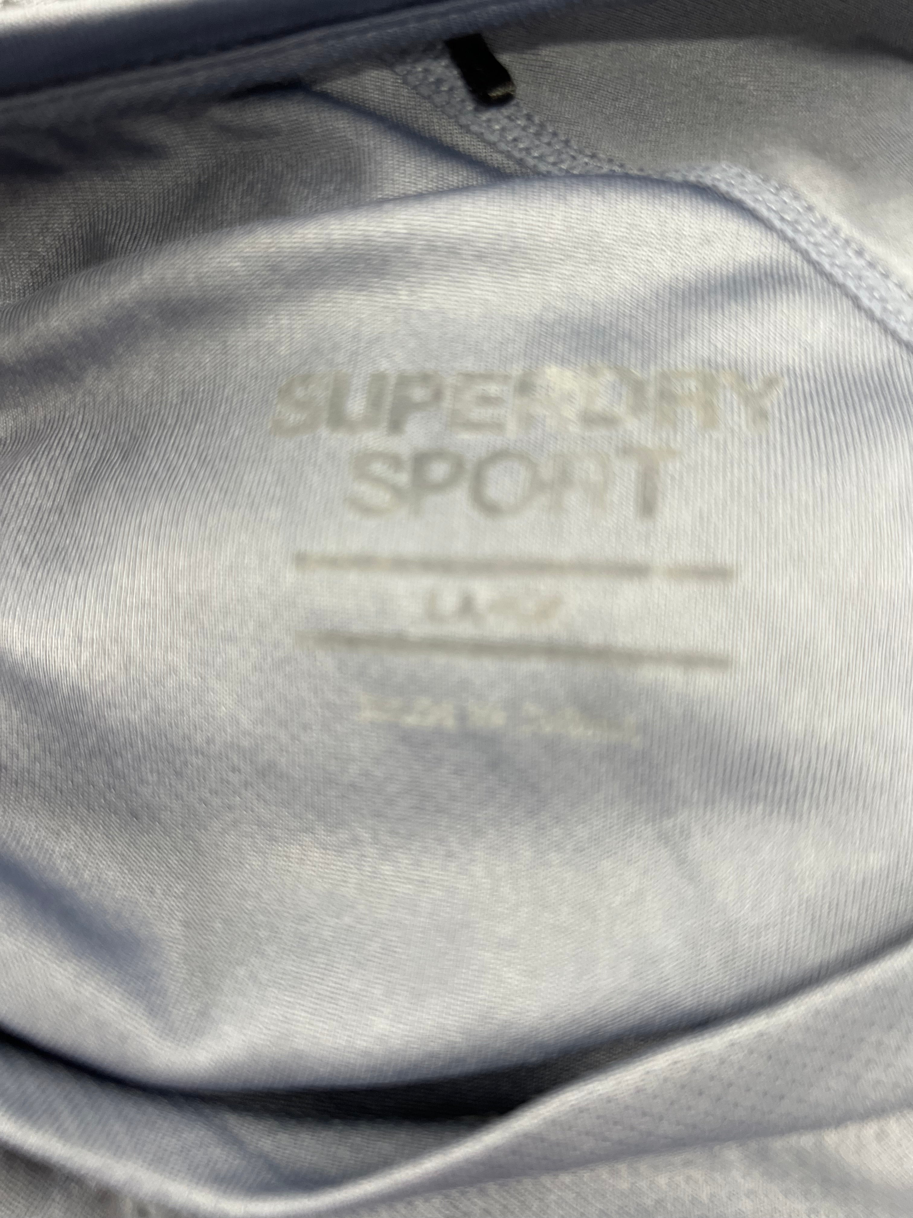 Close-up inside label of Superdry men's sports t-shirt showing size and brand