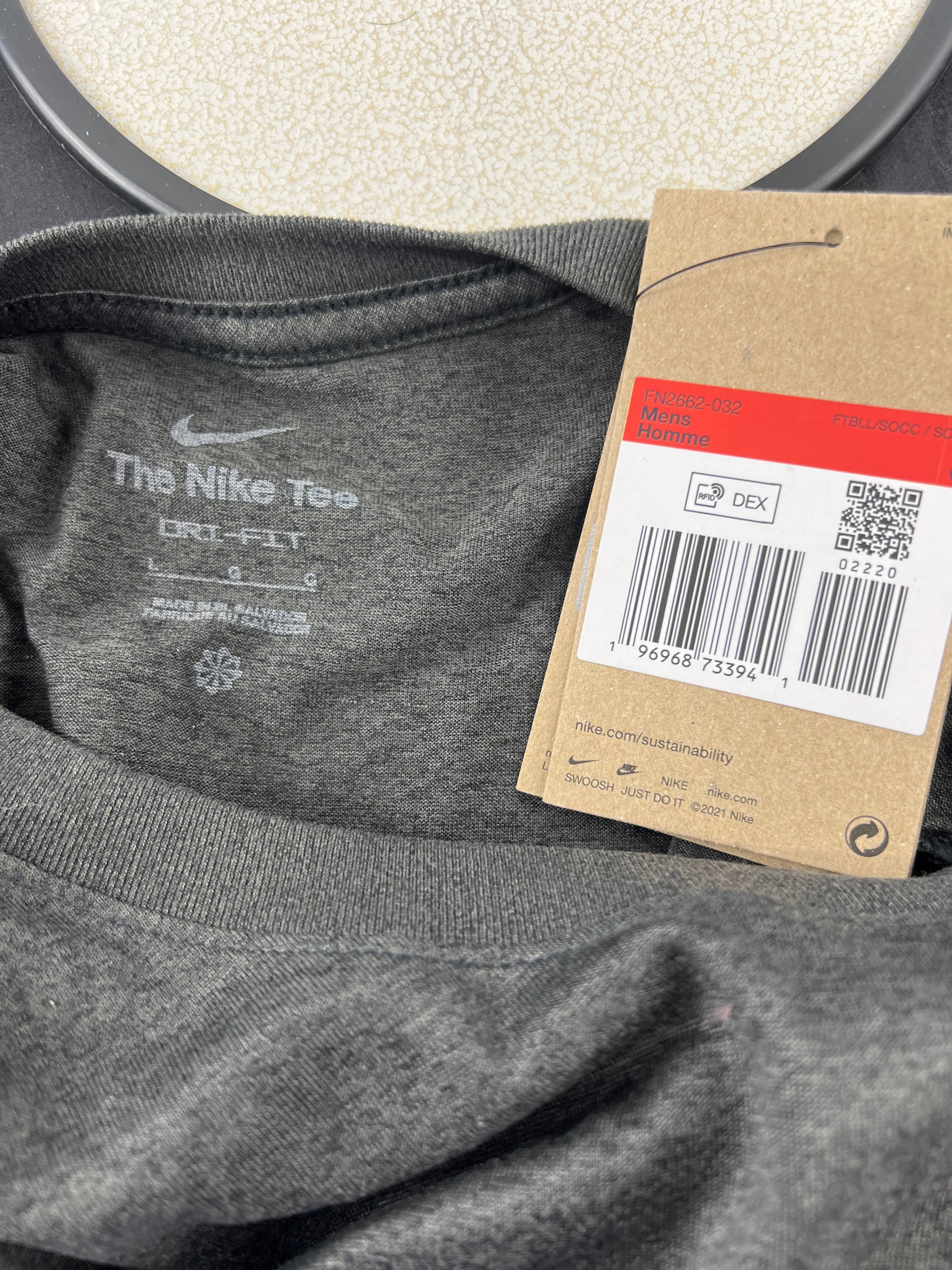Close-up of neckline tag showing Nike 'The Nike Tee' branding and care instructions