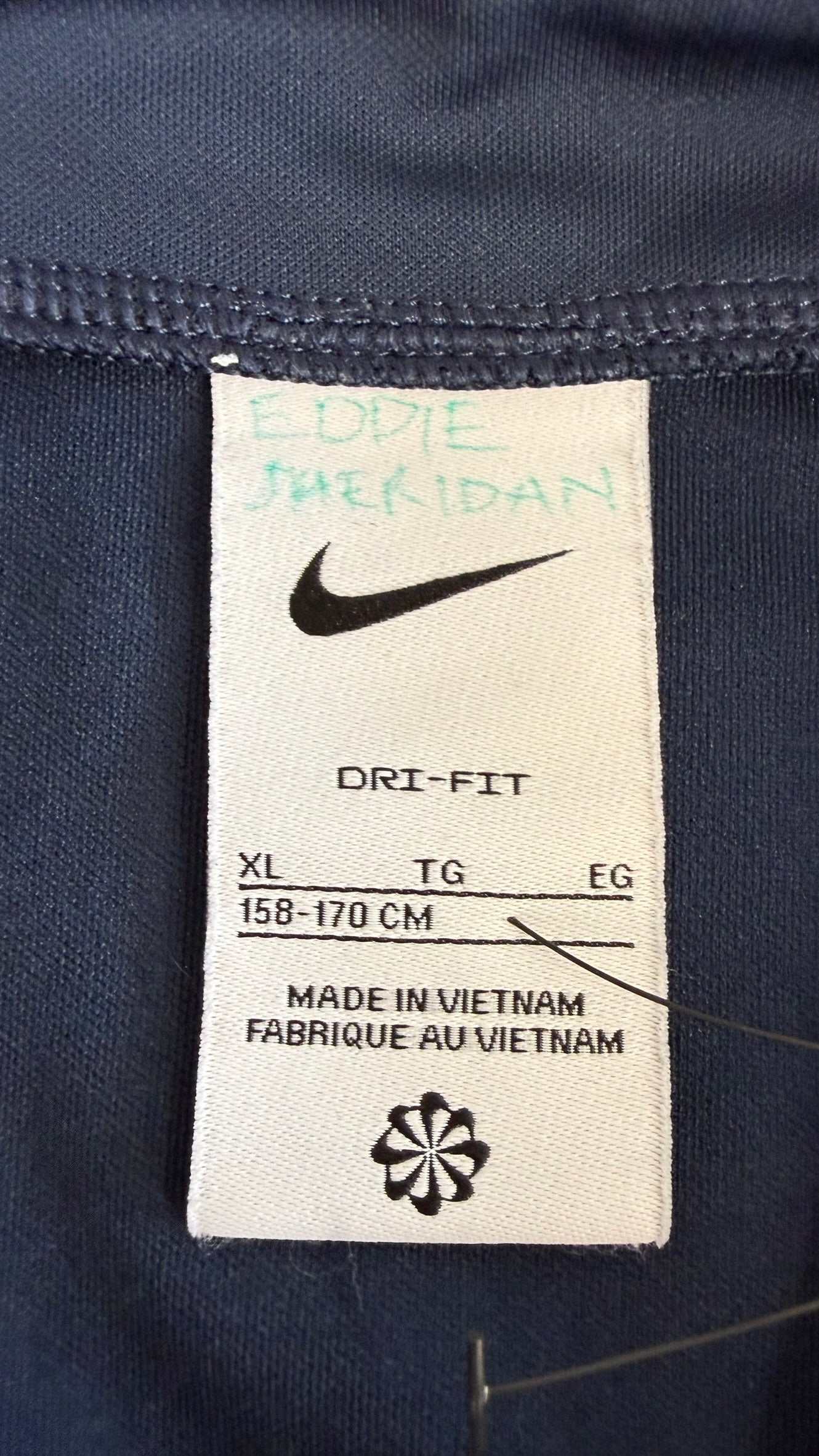 Close-up of the Nike Dri-FIT product label showing size XL (158-170 cm) and made in Vietnam