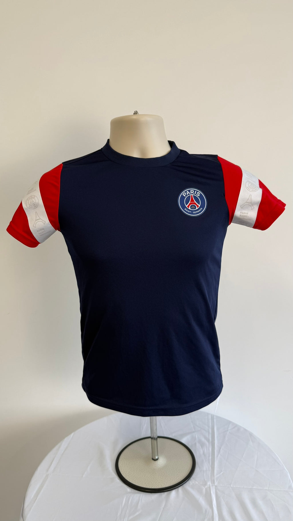 Front view of Paris Saint-Germain kids t-shirt in navy with red sleeves and club badge