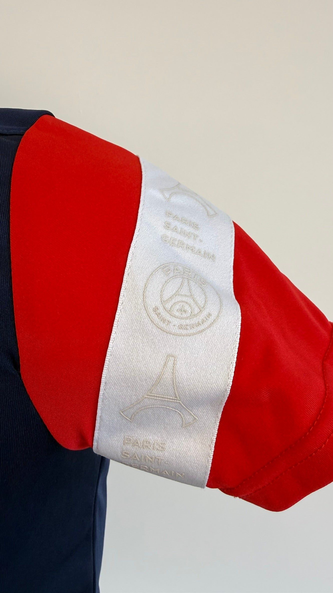 Detail shot of the red sleeve with white PSG and Eiffel Tower band