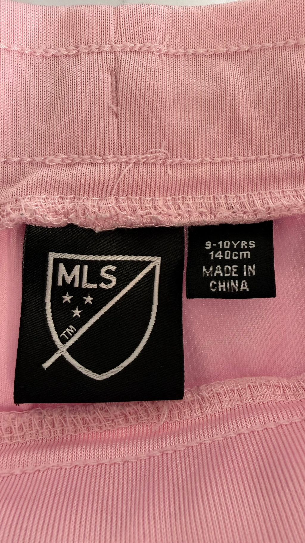 Close-up of size and origin label inside shorts showing size 9-10 years, 140cm, Made in China