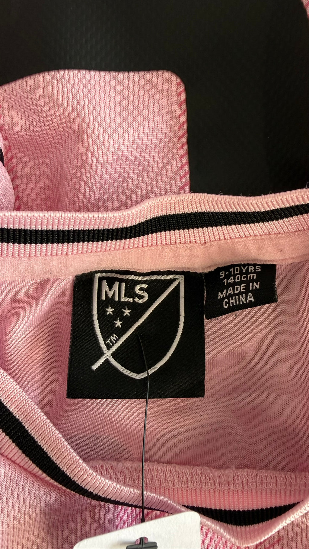 Close-up of size and origin label inside shirt showing size 9-10 years, 140cm, Made in China