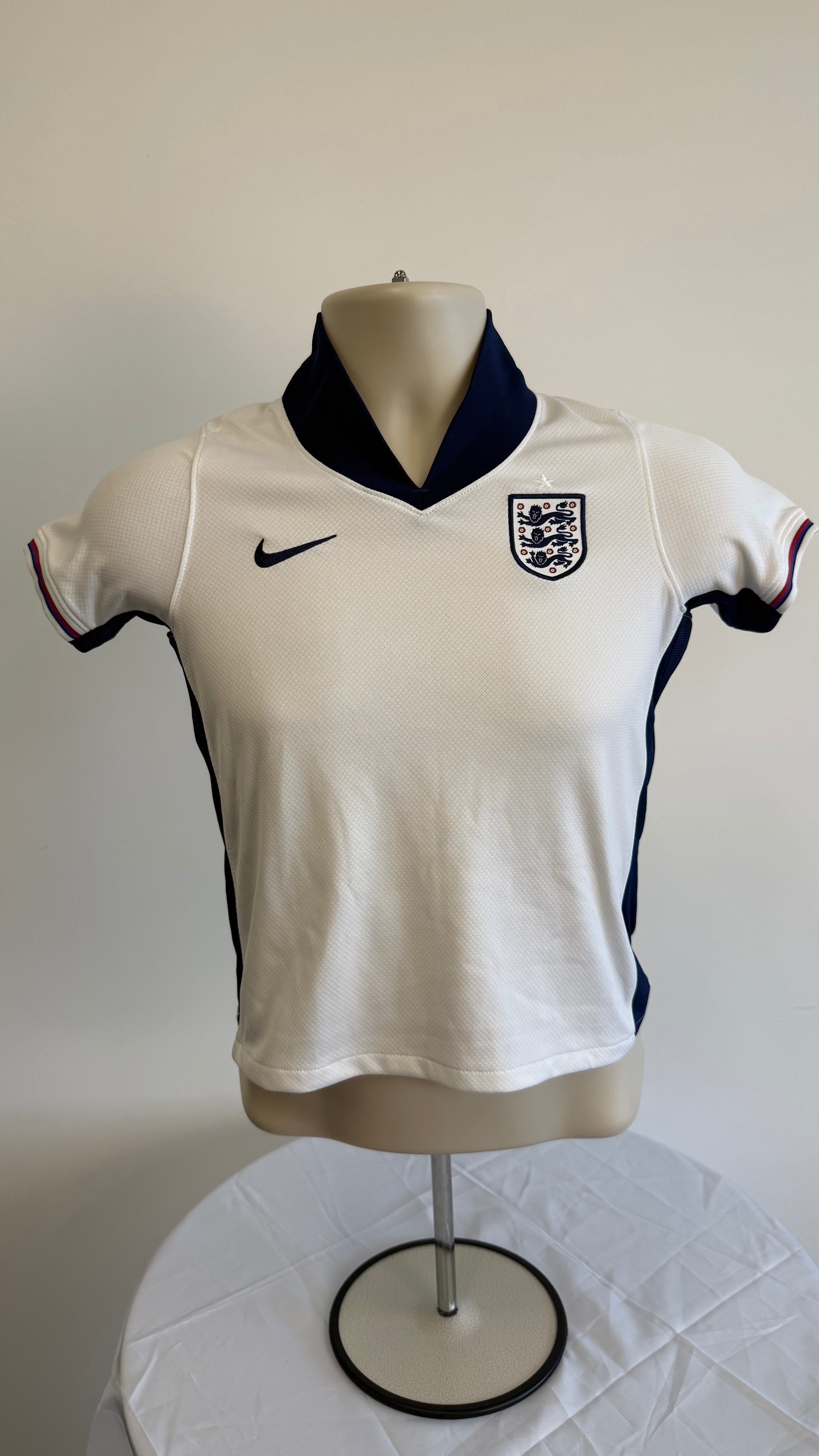 Front of kids England Nike football shirt with navy collar and England crest