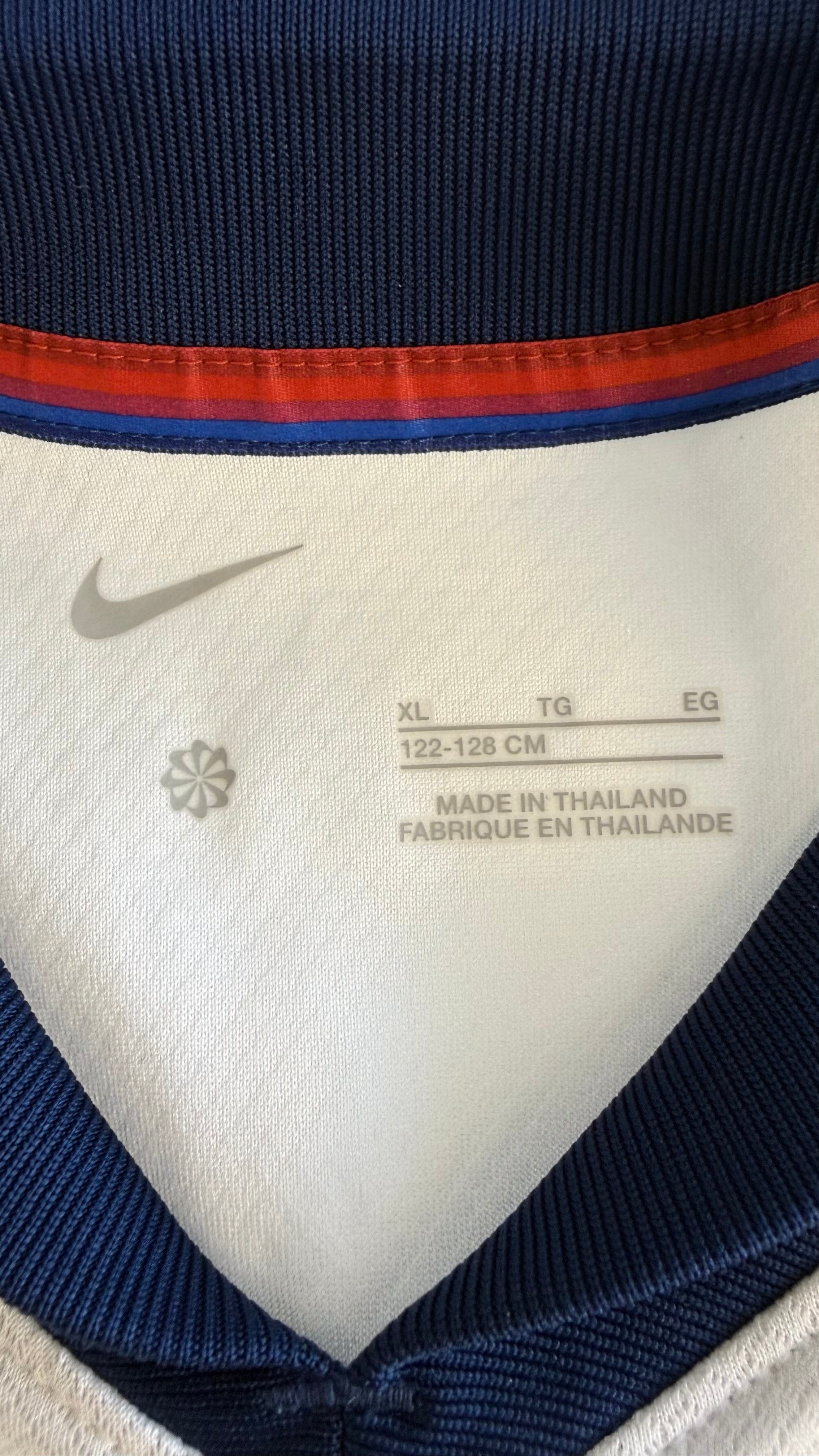 Close-up of inside shirt label showing Nike logo, XL size 122-128cm, and origin