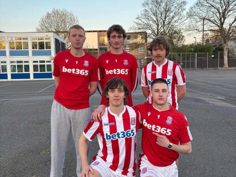 Five young men pose for a team photo wearing Stoke City football jerseys