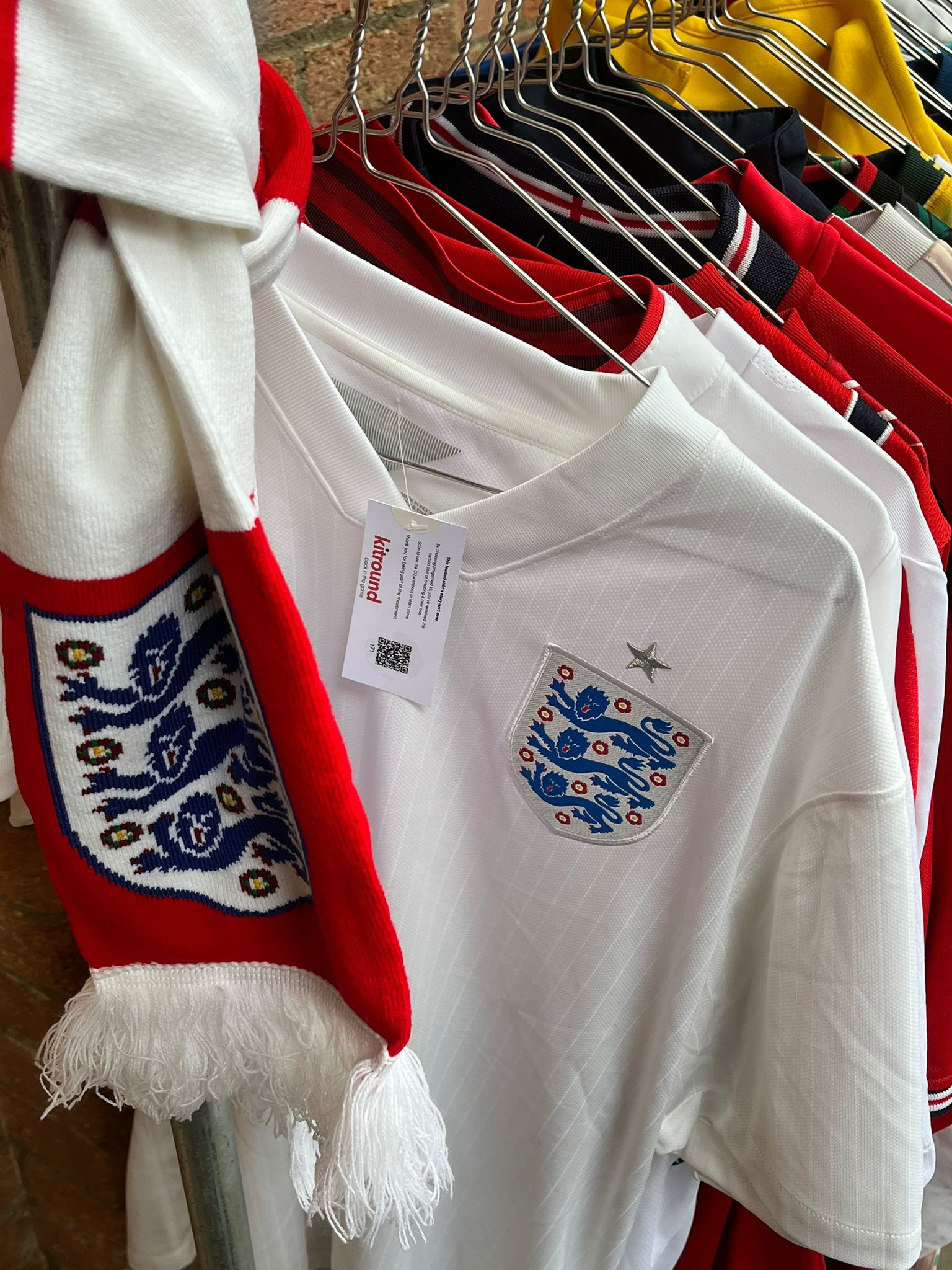 Multiple football shirts for sale on a clothing rack