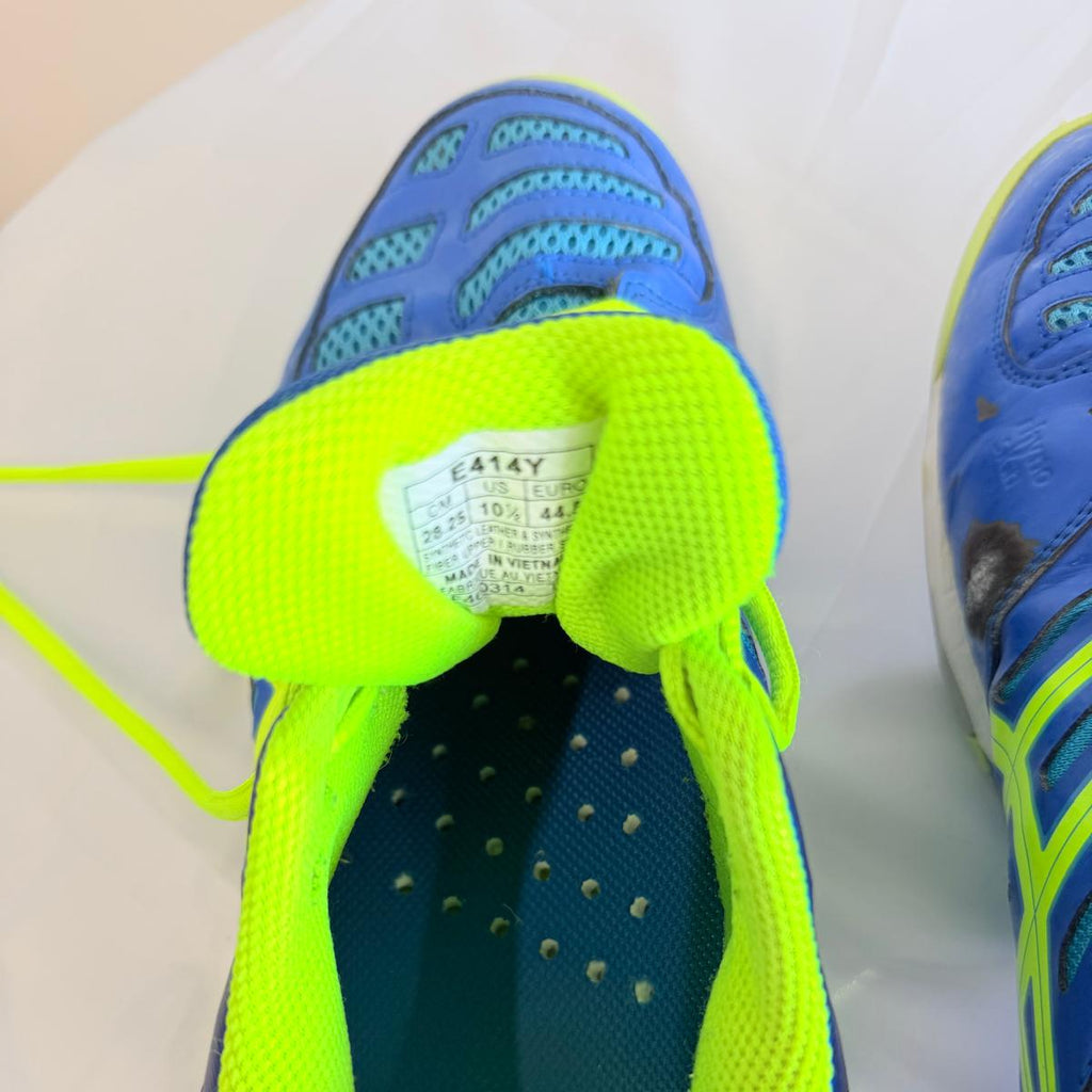 Close-up of ASICS court shoe tongue showing label and lime lining