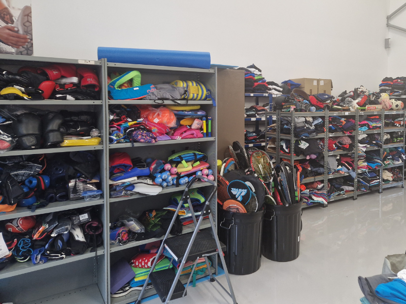 Warehouse racking full of folded sports clothes and equipment