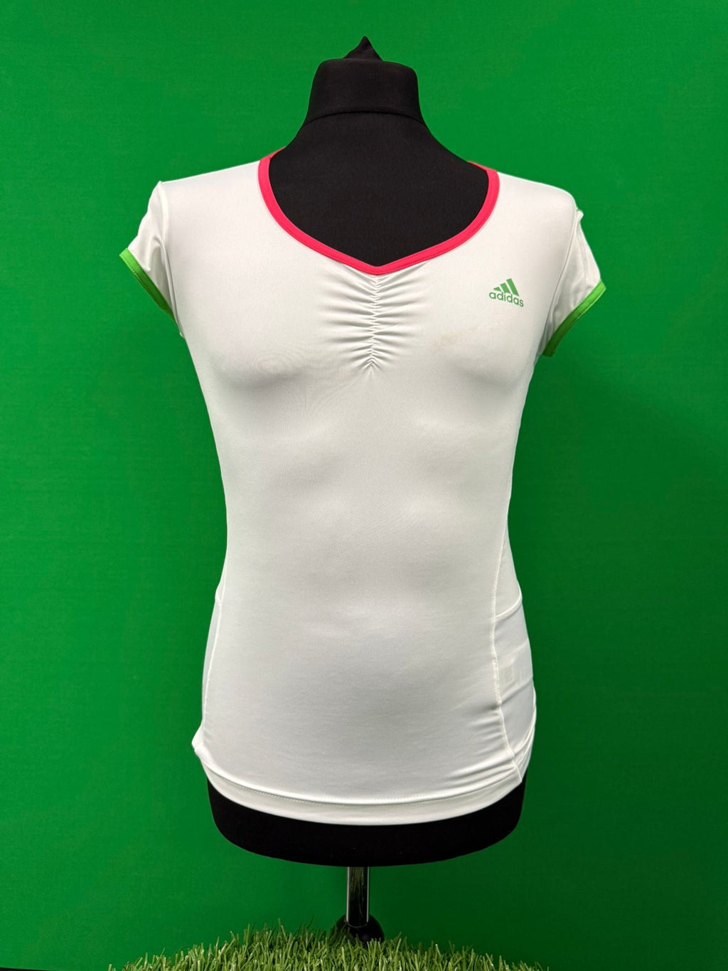 Front view of Adidas Barricade women's tennis top in white with pink neckline and green sleeve trim