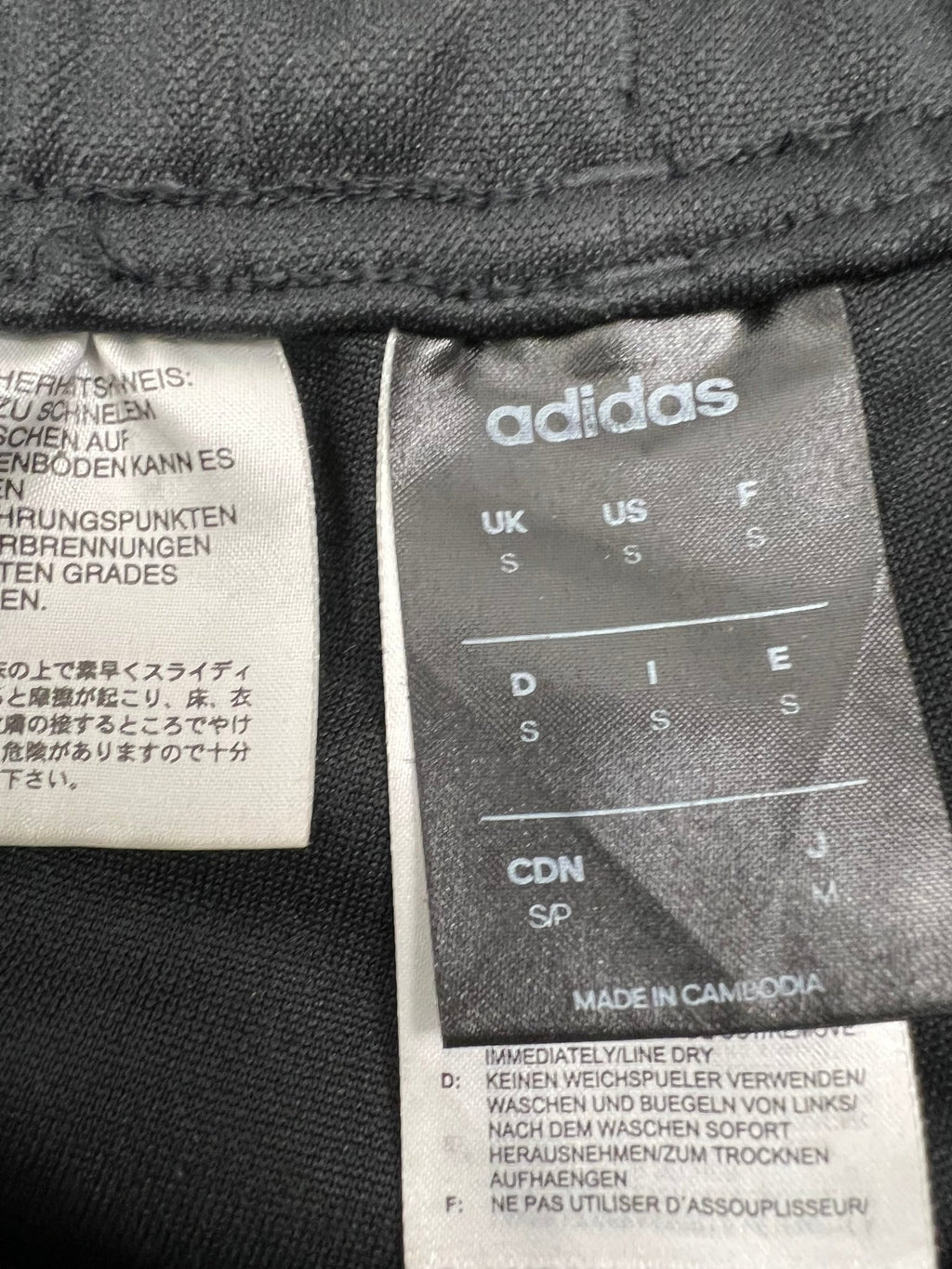Close-up of adidas label showing size S and care instructions