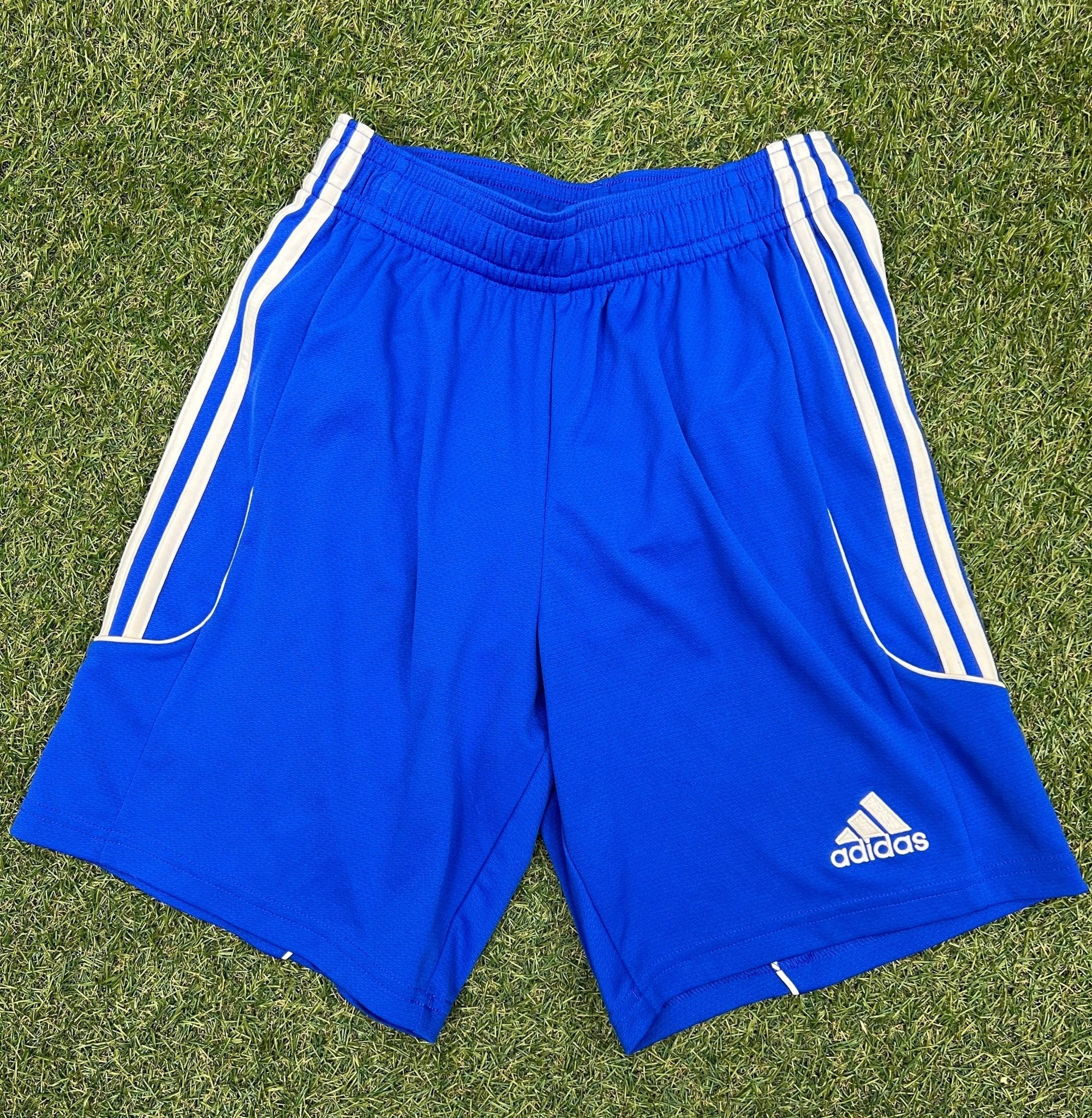 Front view of blue adidas Climalite sports shorts with white stripes