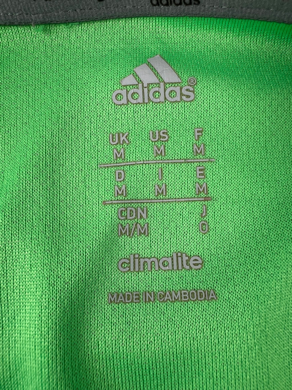Close-up of adidas Climalite medium size tag inside green vest