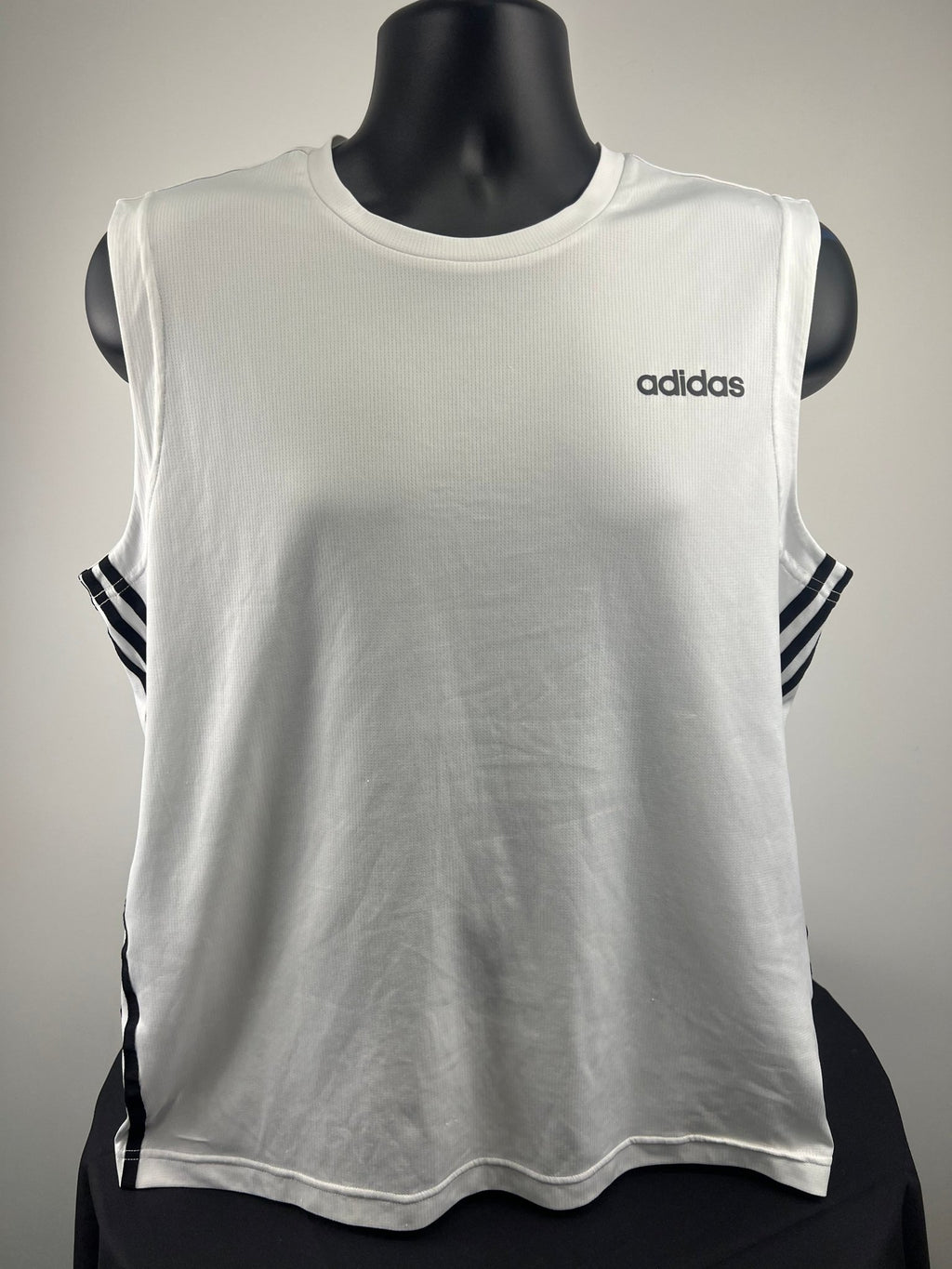 Front view of a white adidas sleeveless vest top with logo