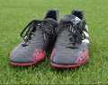 Pair of adidas Predator black football boots on grass pitch