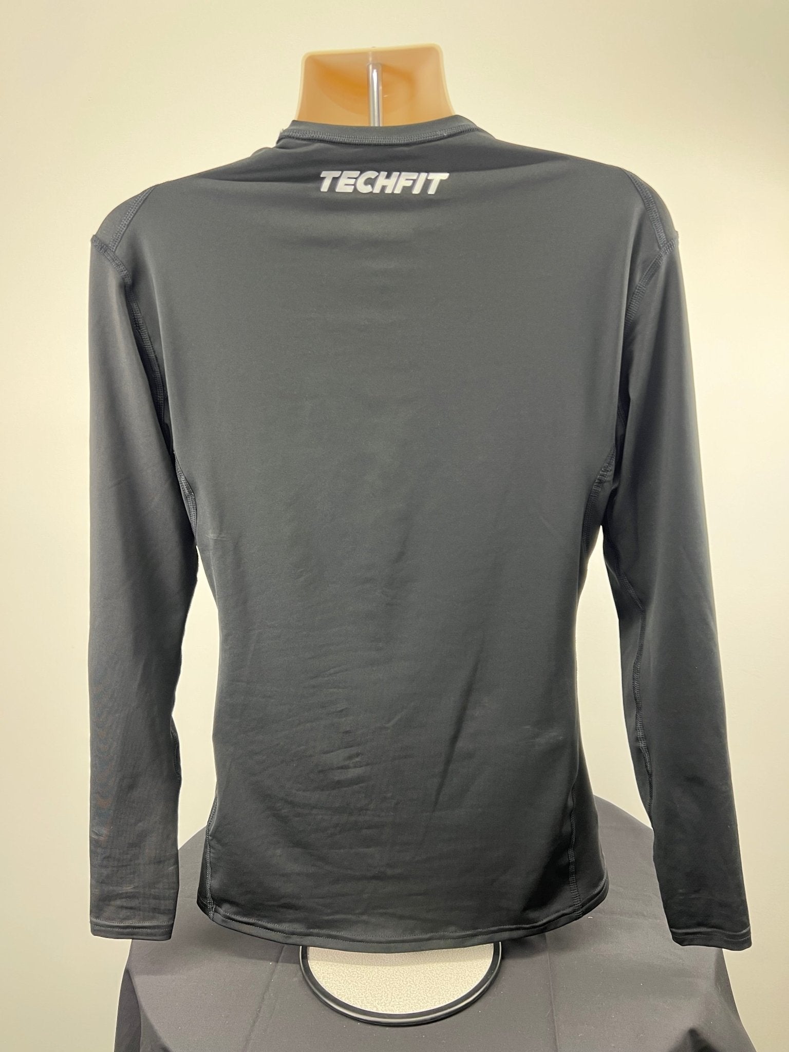 Back view of Adidas Techfit compression long sleeve top in black showing 'Techfit' branding