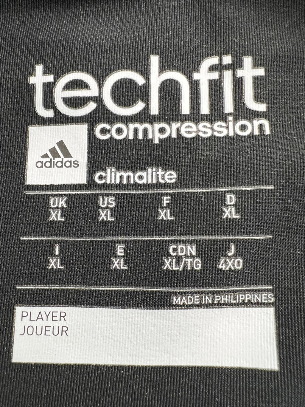 Close-up of Adidas Techfit compression label including sizing and Climalite technology