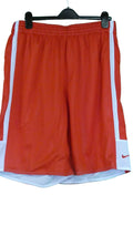 Red Nike basketball shorts with white side stripes, displayed on hanger