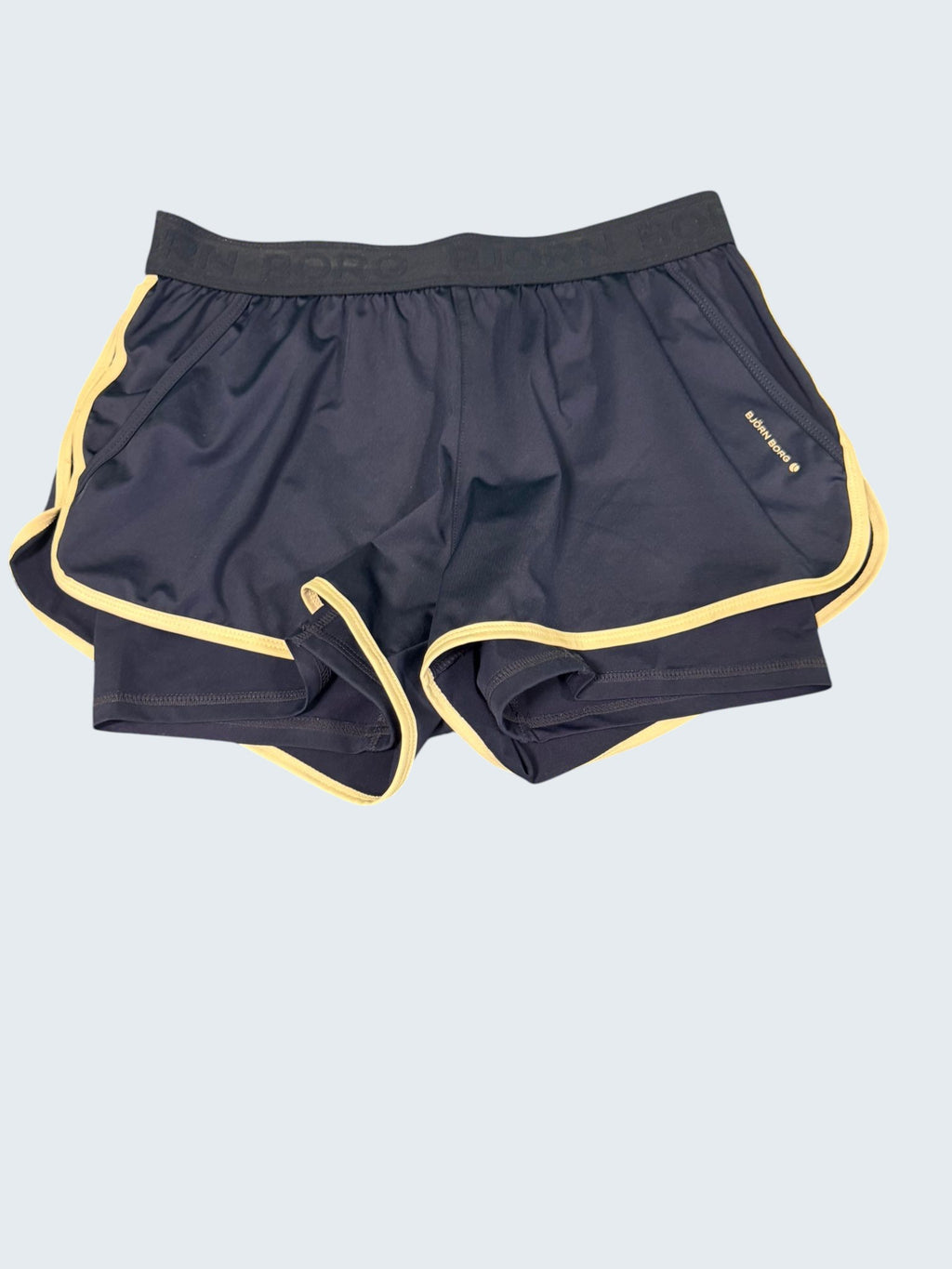 Bjorn Borg women's dark blue tennis shorts with cream piping and elastic waistband. Lightweight, breathable, moisture-wicking fabric.