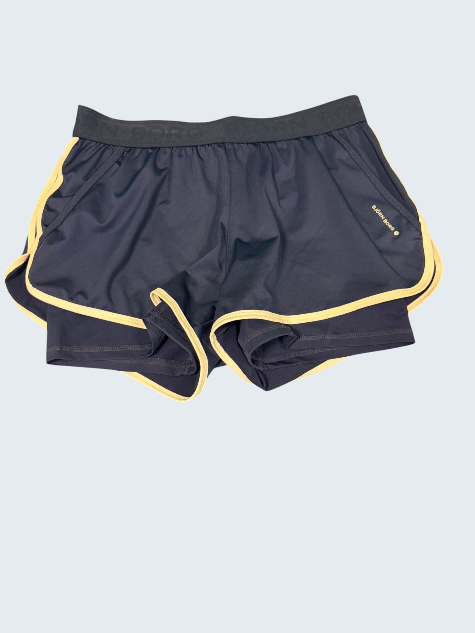 Bjorn Borg women's dark blue tennis shorts with cream piping and elastic waistband. Lightweight, breathable, moisture-wicking fabric.
