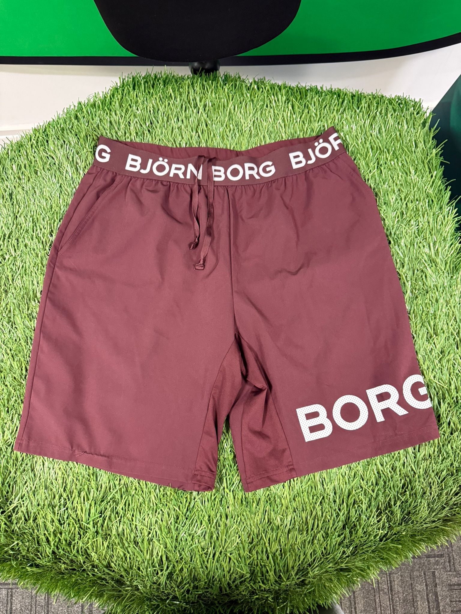 Front view of Björn Borg maroon training shorts with branded waistband and logo on leg