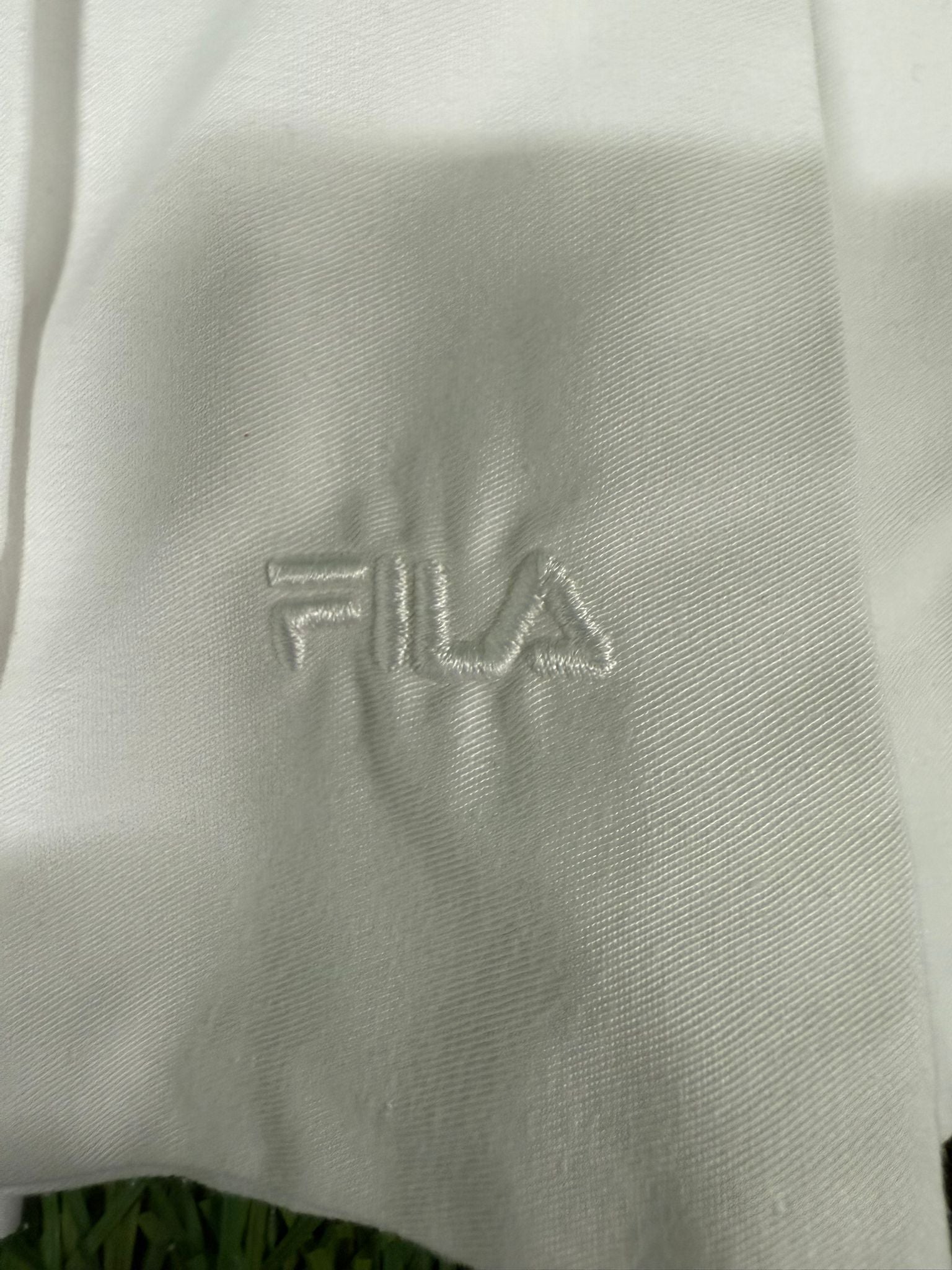 Close-up of white Fila tennis skirt showing embroidered Fila logo