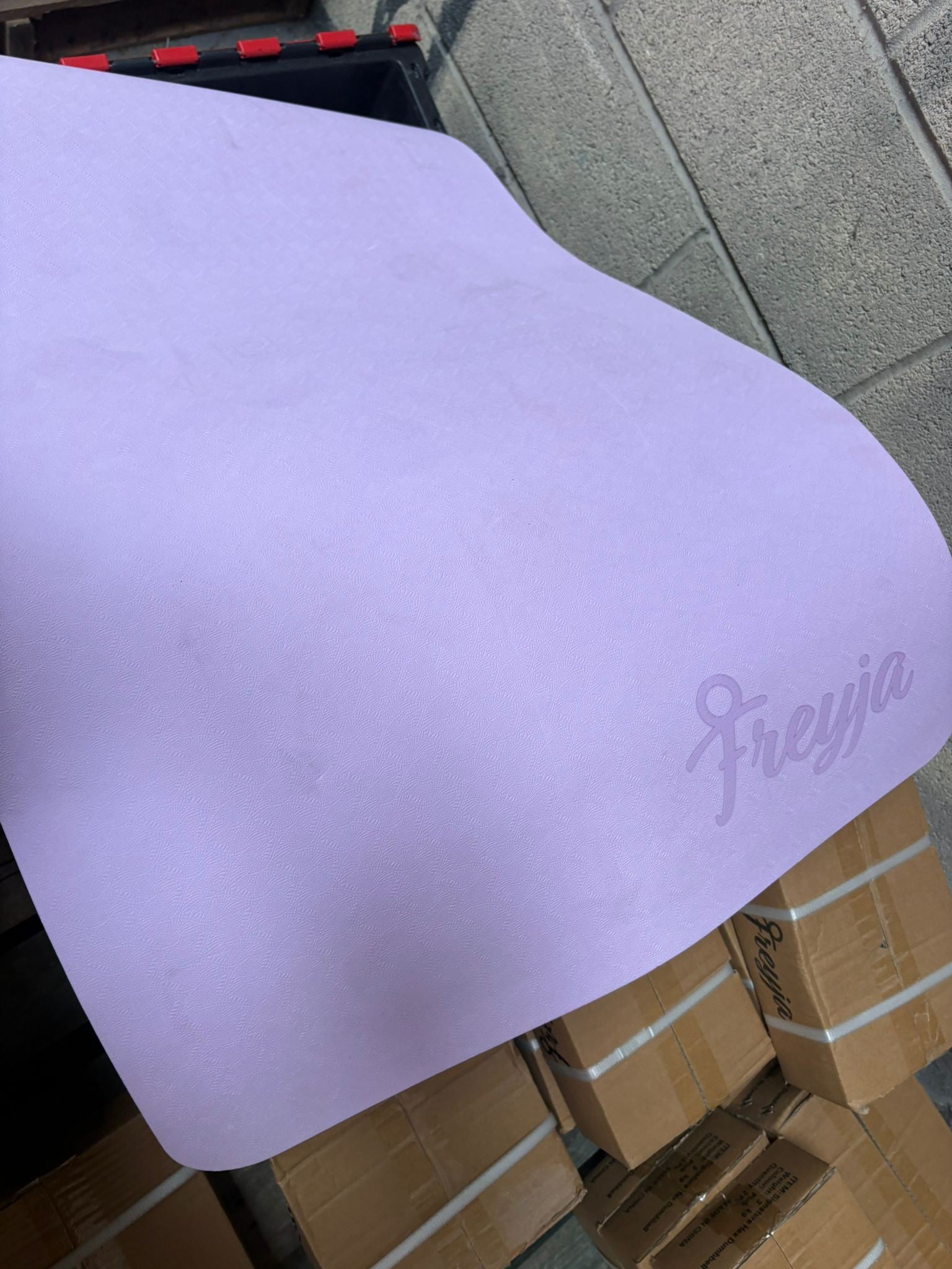 Purple yoga mat with Freya logo on one corner