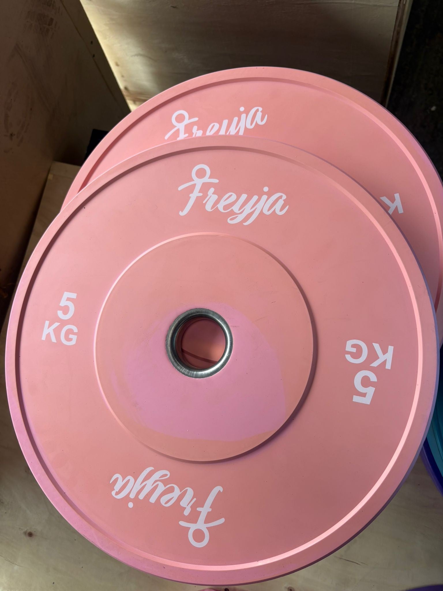 Two stacked 5kg pink bumper weight plates with Freyja branding and steel centre rings