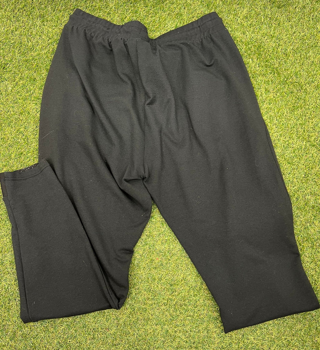 Back view of Gymshark black tracksuit bottoms size L on grass