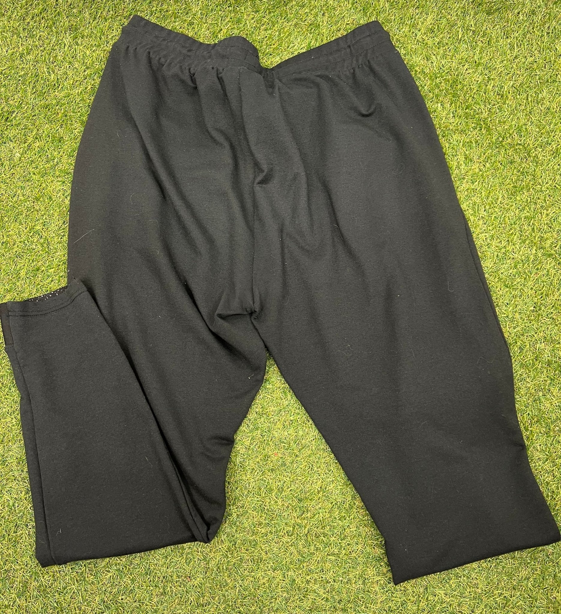 Back view of Gymshark black tracksuit bottoms size L on grass