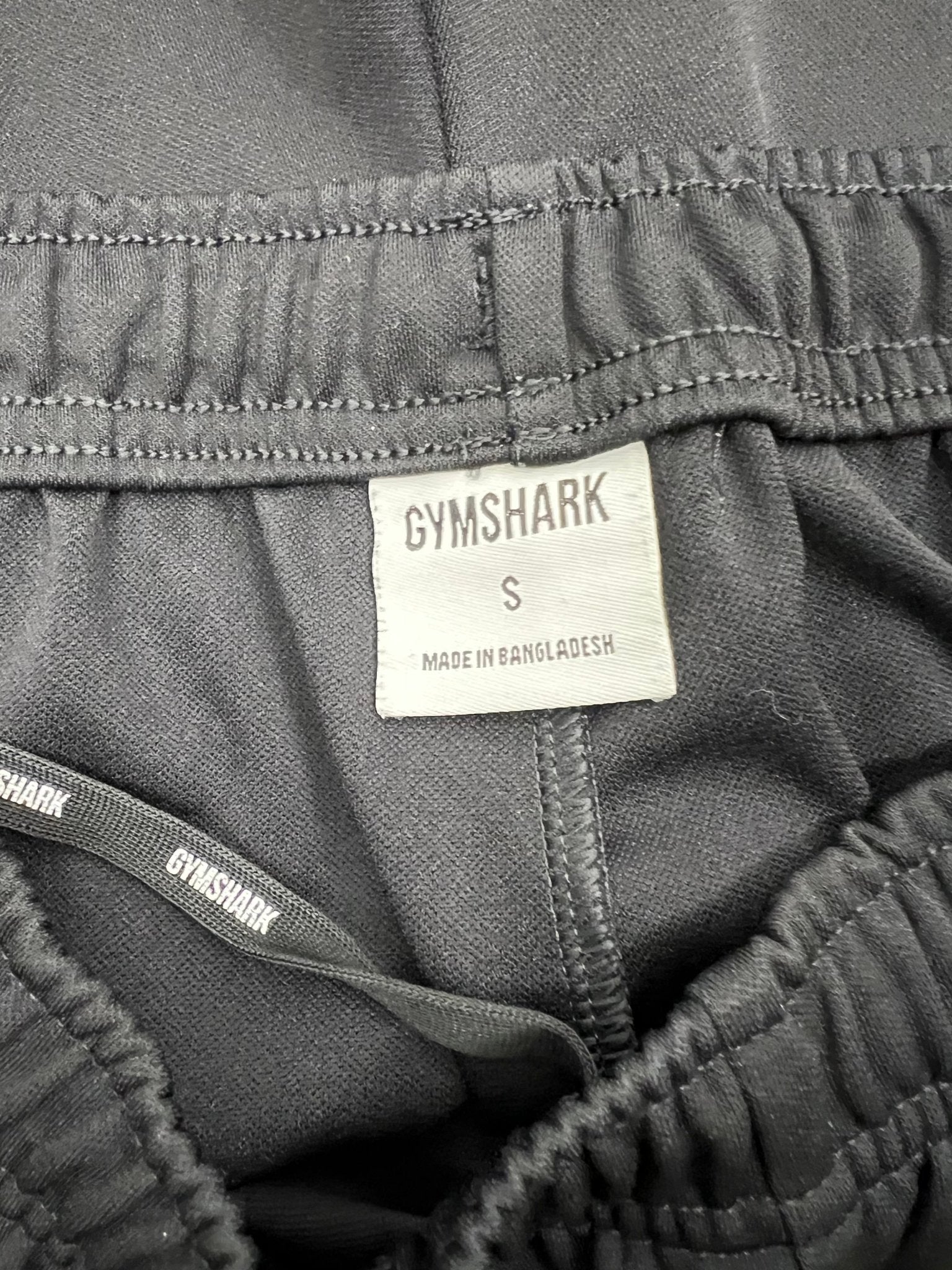 Close-up of Gymshark label and waistband inside black tracksuit bottoms