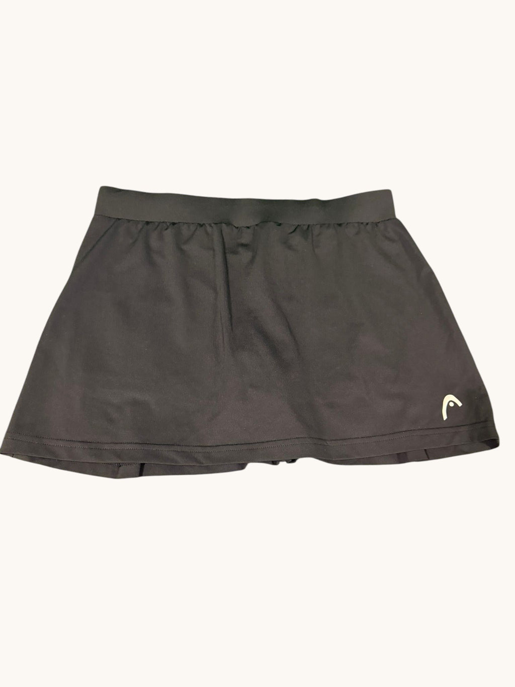 Black HEAD tennis skirt with wide waistband and subtle pleats, lightweight and stretchy fabric.