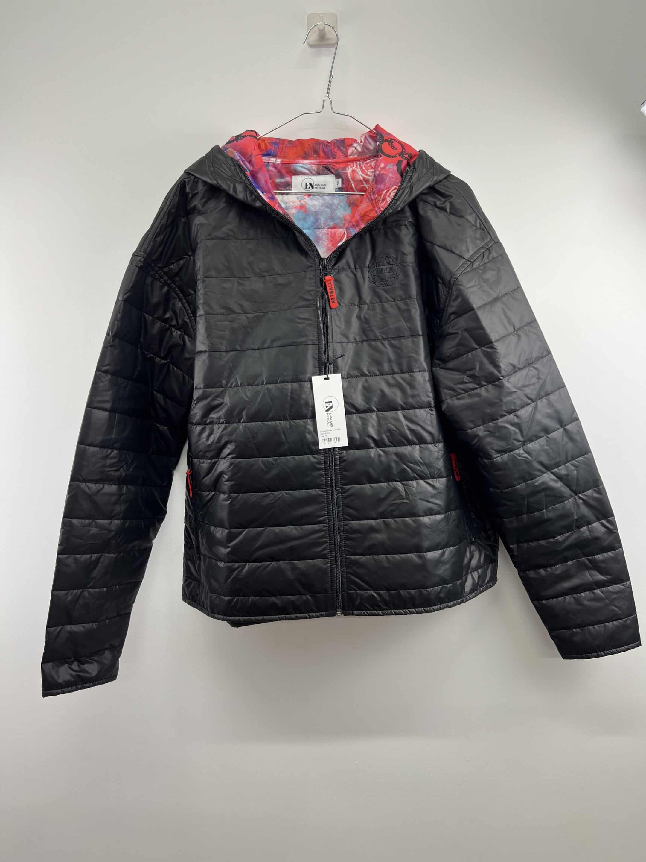 Front view of England Netball women's black quilted jacket with graffiti lining and zip closure