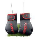 Front view of black and red RDX boxing gloves standing upright
