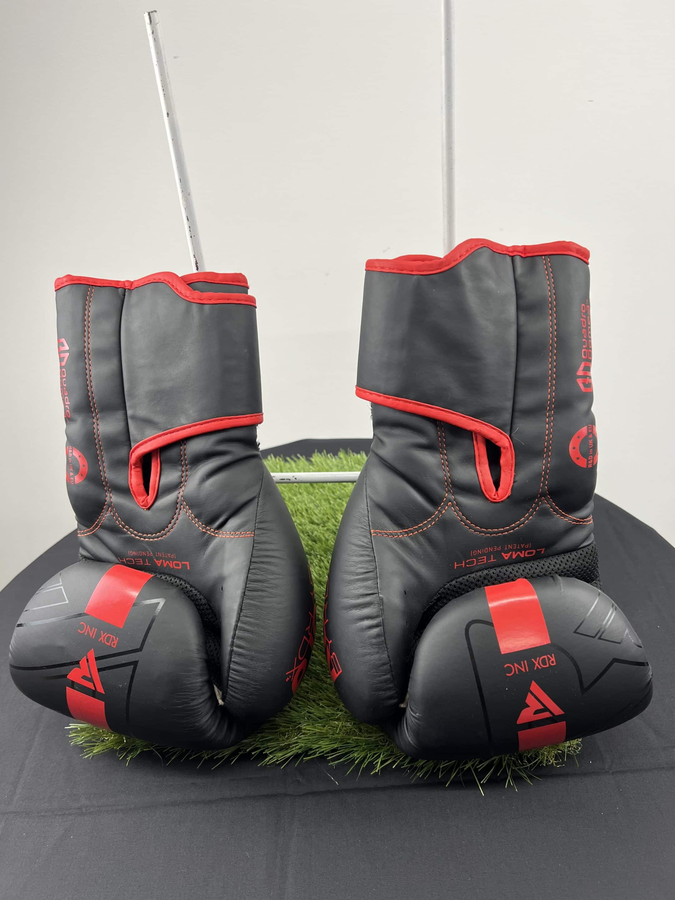 Side view of RDX boxing gloves showing red stitching and palm ventilation