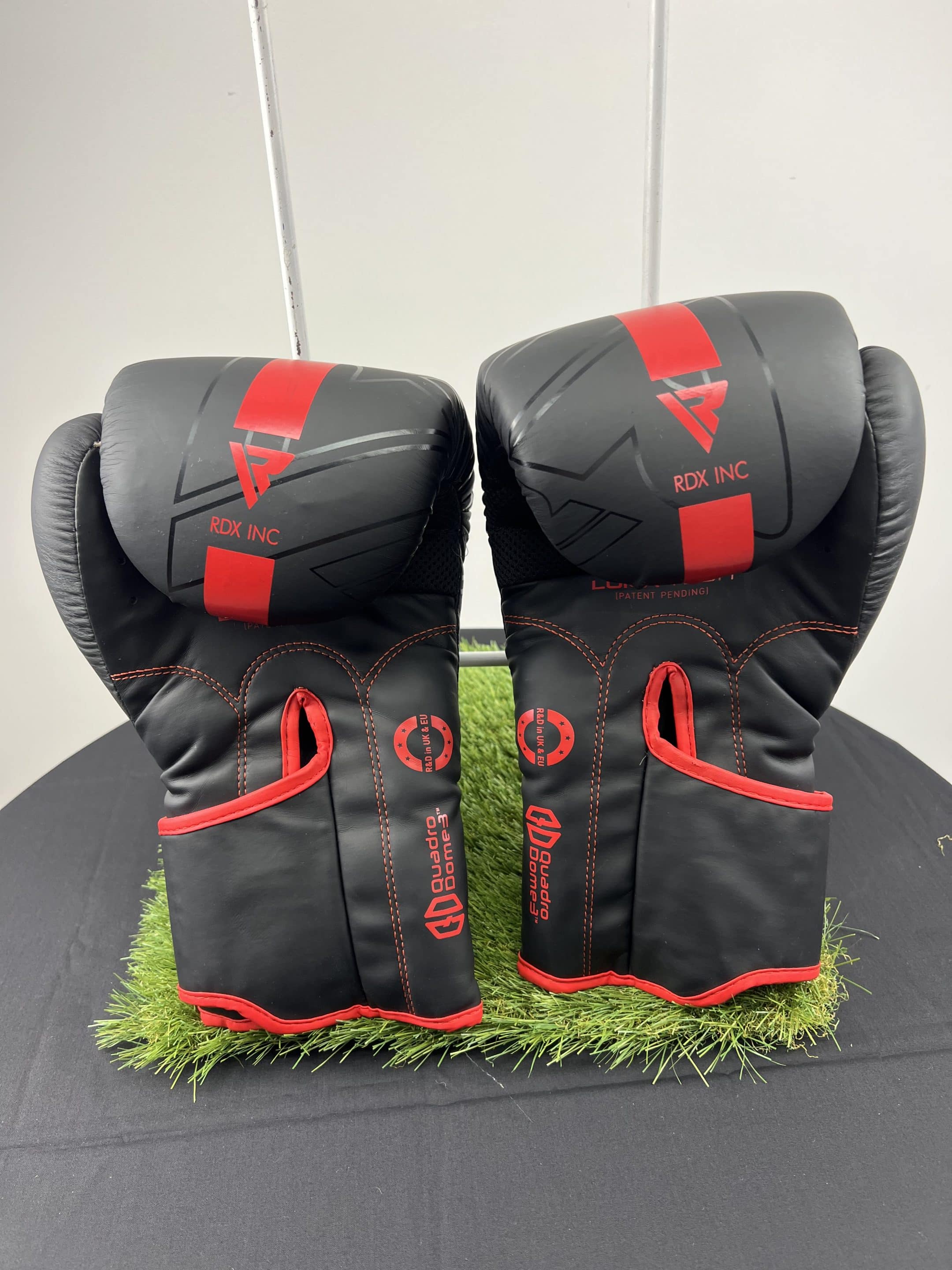 Back view of RDX boxing gloves with red accents and branding