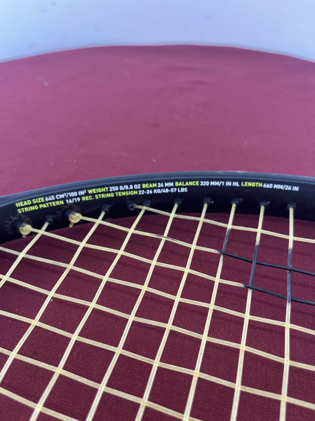 String bed close-up showing specifications on the racquet frame