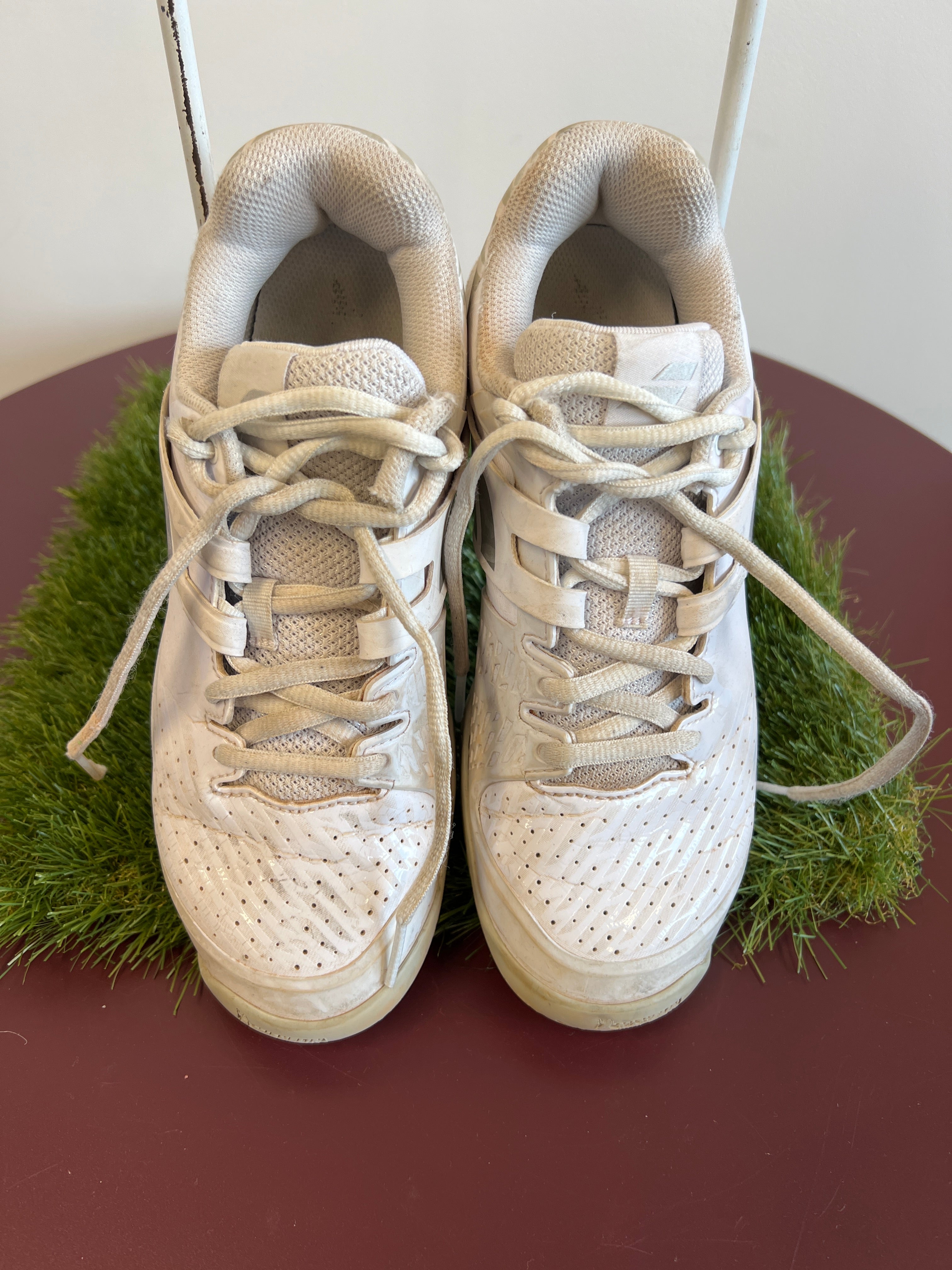 Top-down view of white Babolat Propulse Junior tennis shoes with mesh uppers and laces