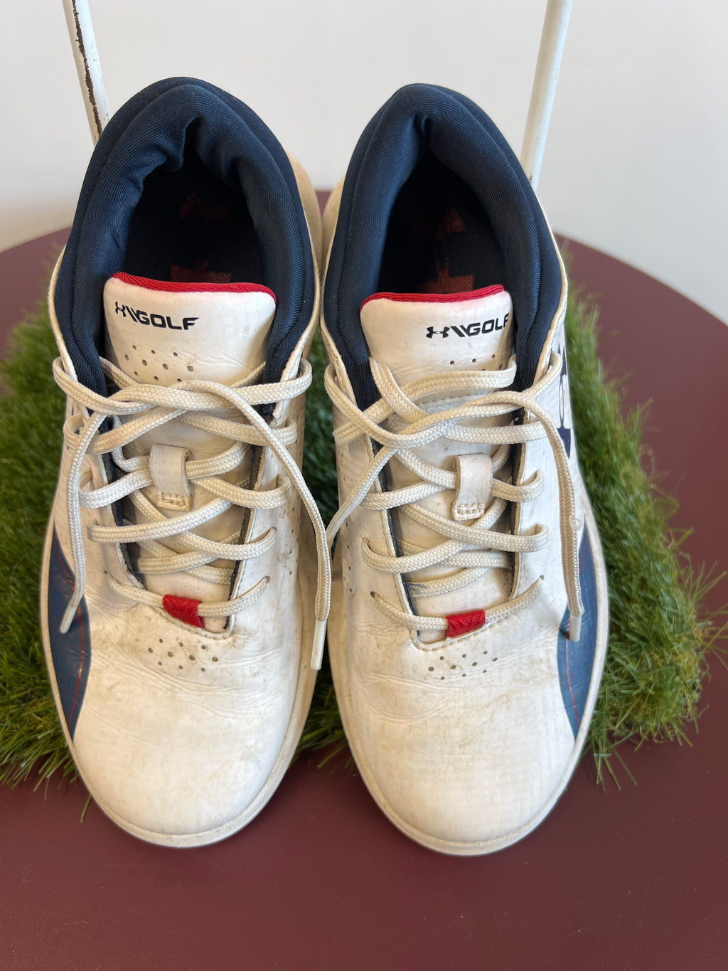 Top view of Kids Under Armour white and navy golf shoes with laces tied