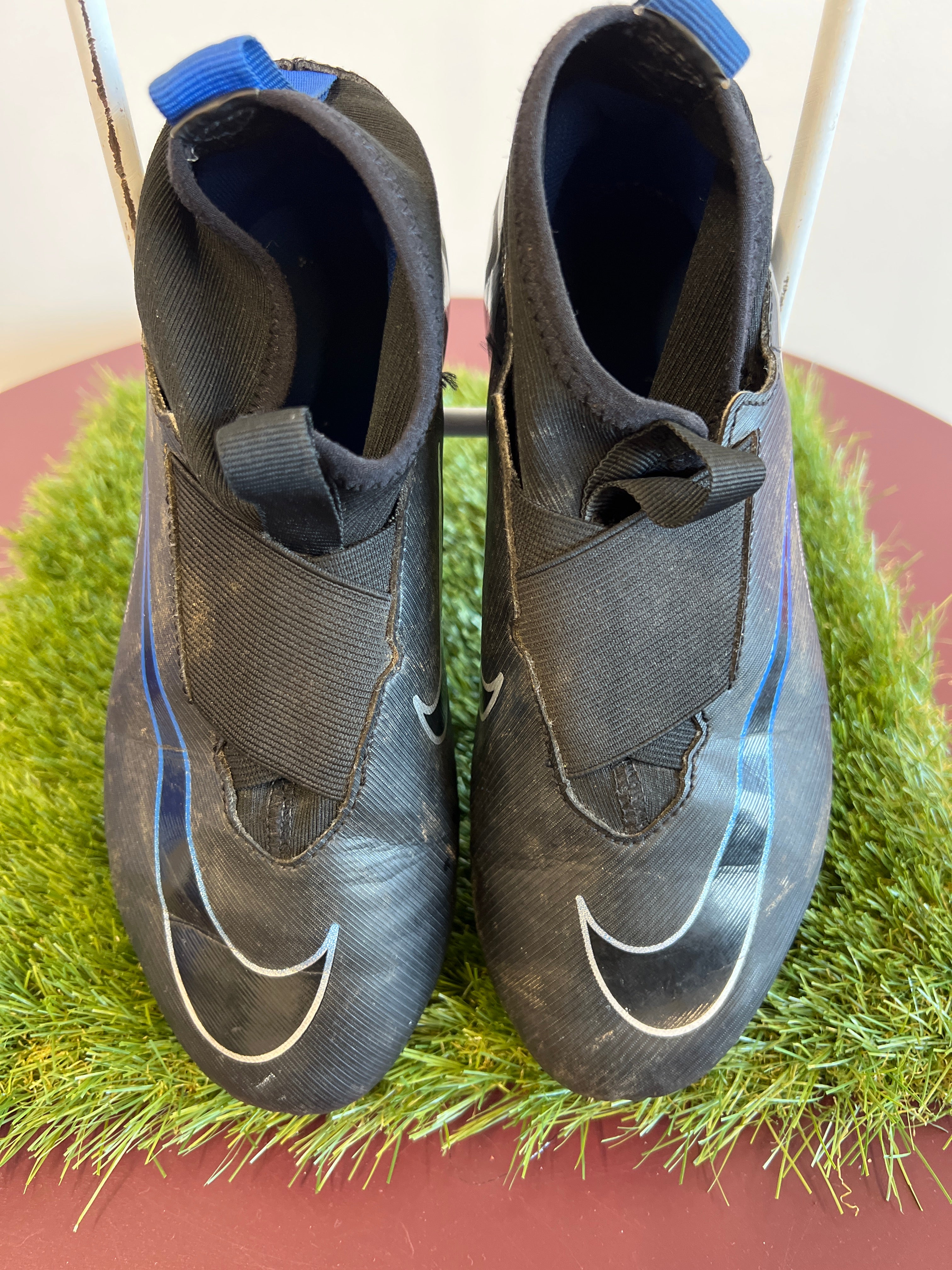 Front view of kids Nike Mercurial football boots in black with blue details and elastic strap
