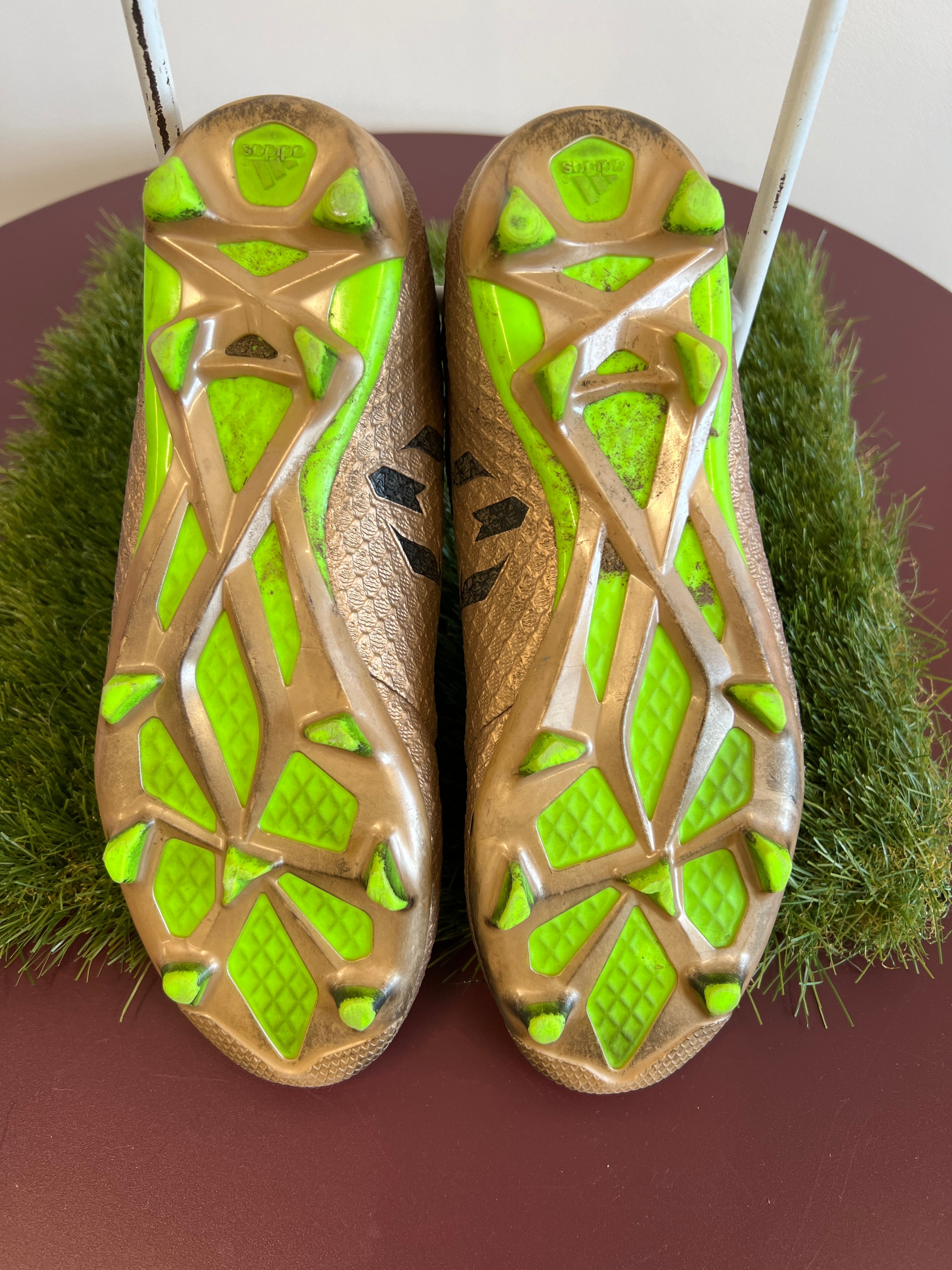 Sole of kids adidas football boots showing bright green studs and grip design