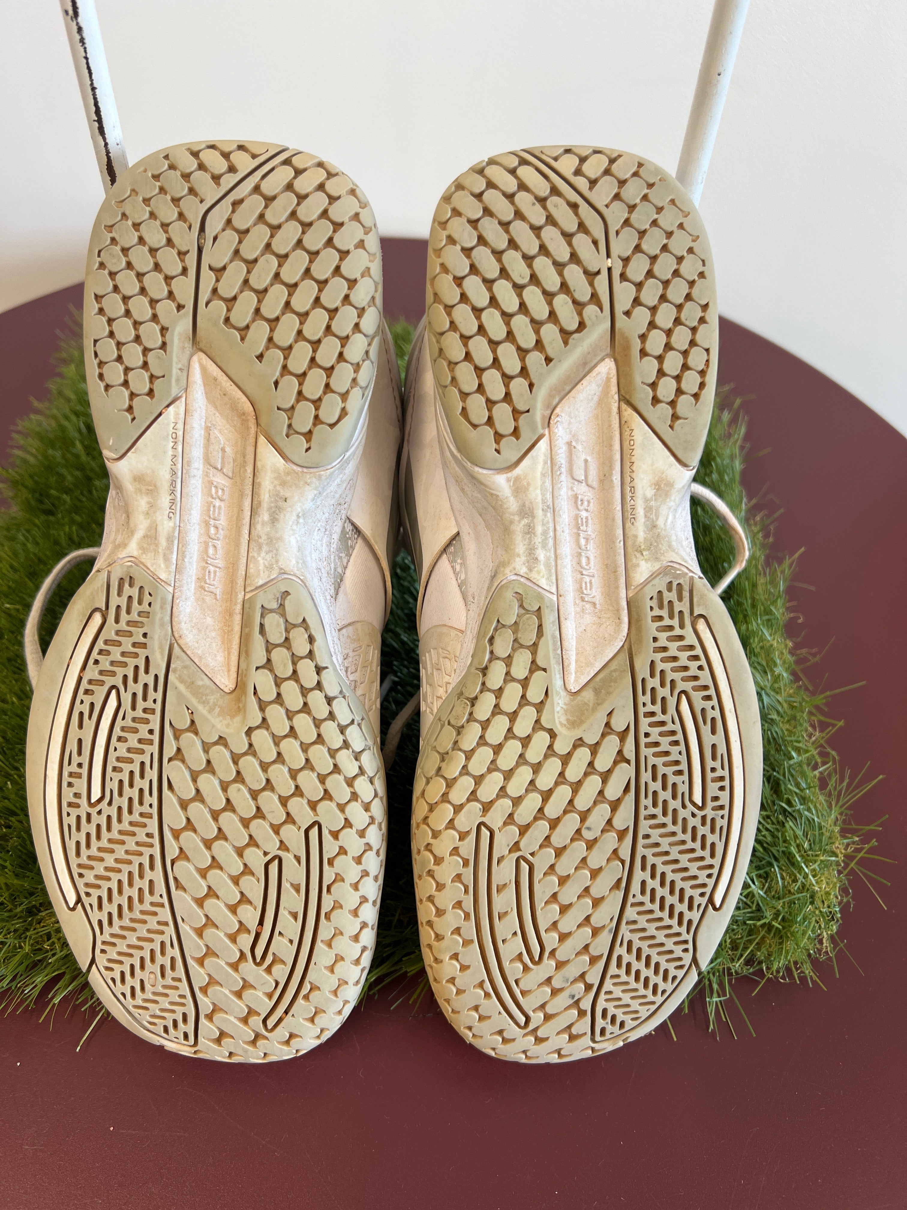 Soles of Babolat Propulse Junior tennis shoes highlighting non-marking tread pattern