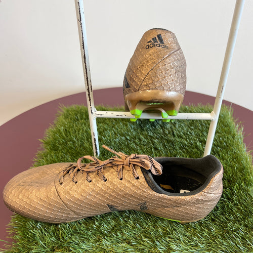 Side and rear view of gold adidas football boots showing black adidas logo on heel