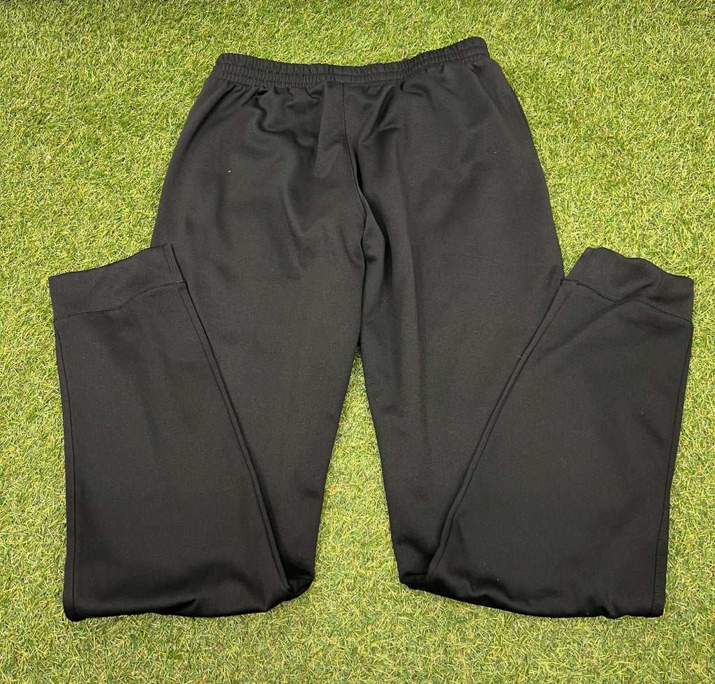Back view of black Joma tracksuit bottoms on grass background