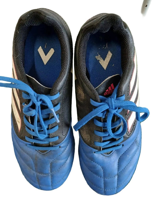 Pair of adidas kids football boots in blue and black, viewed from above