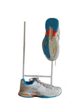Pair of Babolat kids white tennis trainers with blue and yellow accents on a grass display with branded background
