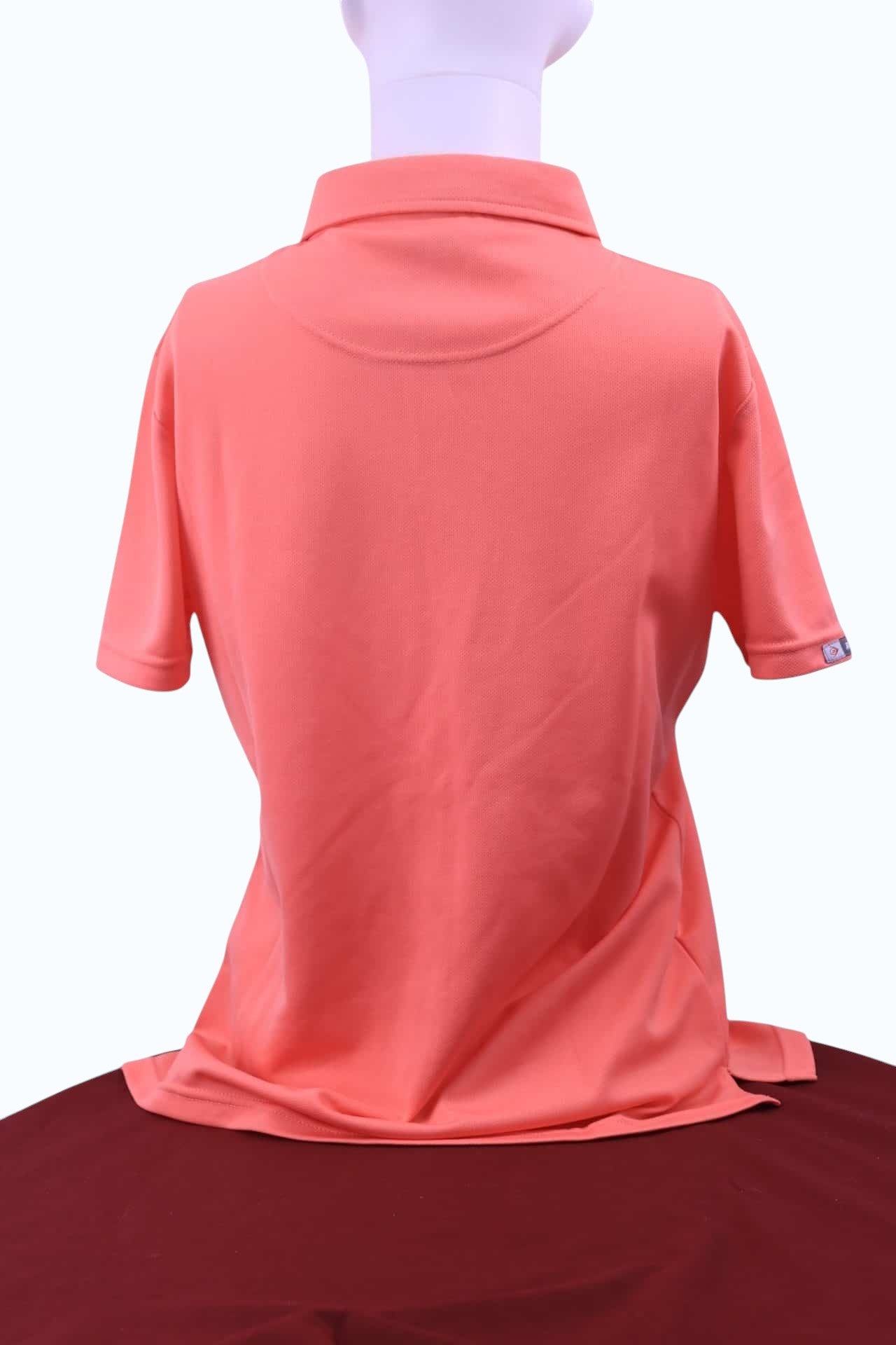Women's kitround Dunlop Sport polo shirt in melon orange with press stud buttons and logo.