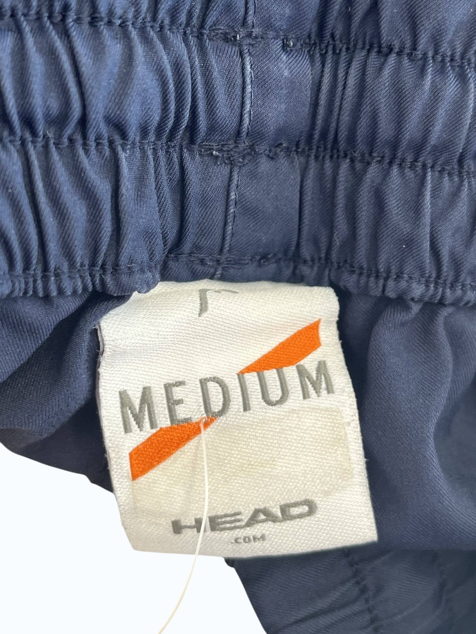 Dark blue HEAD men's tennis shorts with elastic waistband and medium size tag.