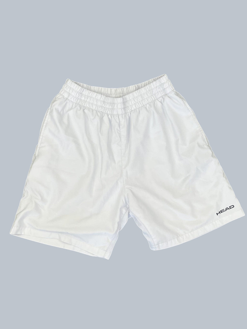 White Head tennis shorts with elastic waistband and breathable fabric. Features Head logo on the right leg.