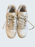 Pair of white Babolat junior tennis shoes from above.